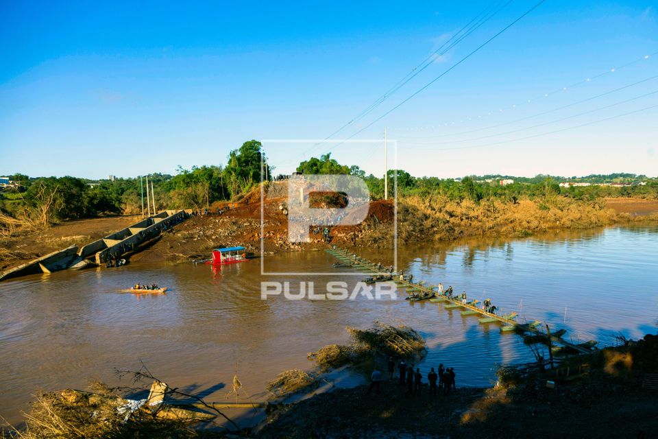 Passarela flutuante improvisada sobre Rio Forqueta controlada por militares e voluntários e ponte destruída 