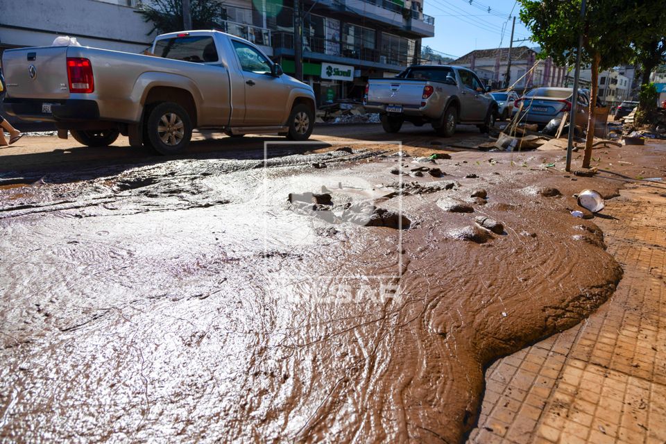 Lama na calçada e veículos trafegando após as enchentes no Vale do Taquari no Vale do Taquari
