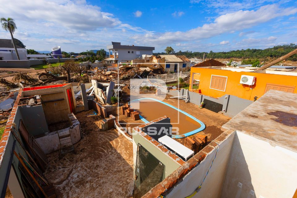 Vista de cima de casa destruída e piscina cheia de lama após enchente no Vale do Taquari
