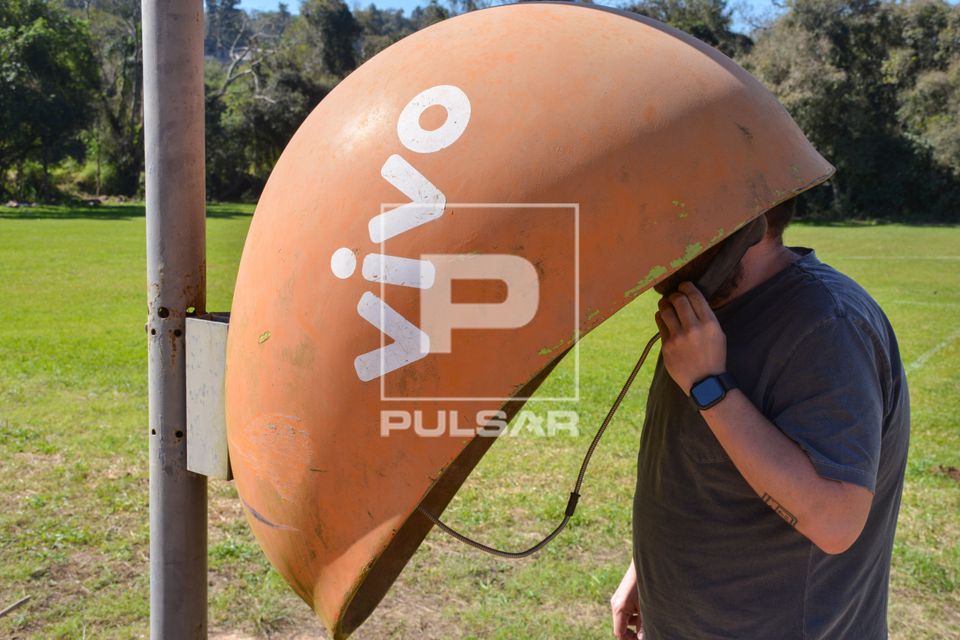 Homem usando orelhão - telefone de uso público