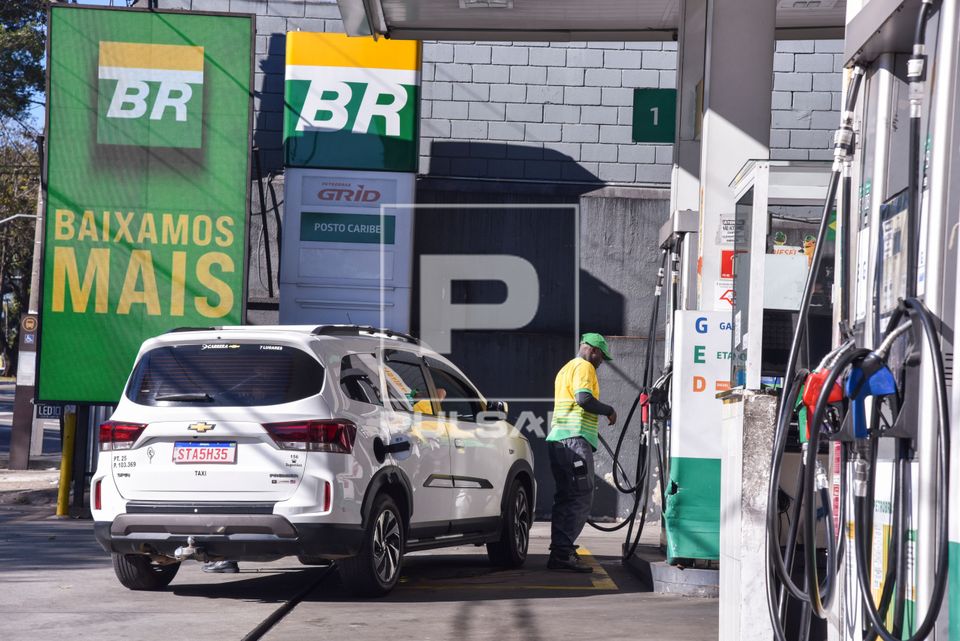 Frentista abastecendo carro em posto de combustíveis