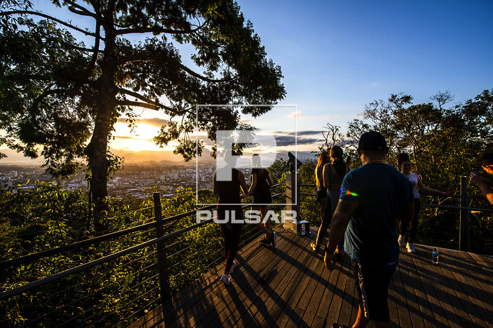 Pessoas apreciam paisagem do pôr do sol a partir do mirante do morro da Boa Vista - 