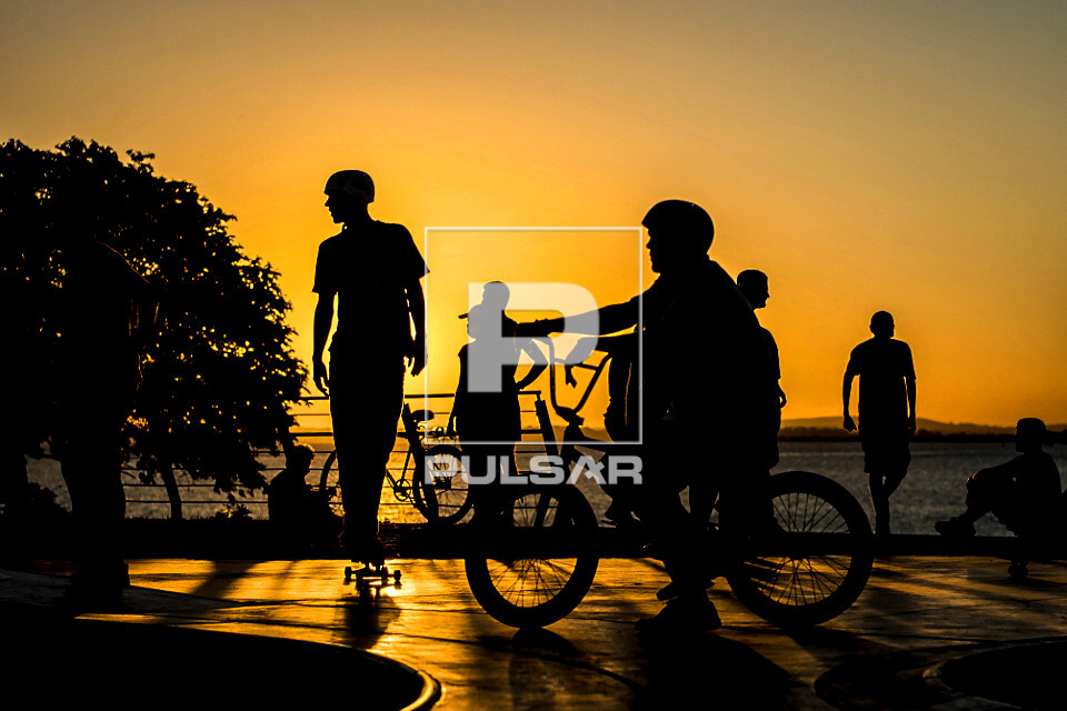 Jovens em pista de skate com o pôr do sol na orla do Guaíba - 
