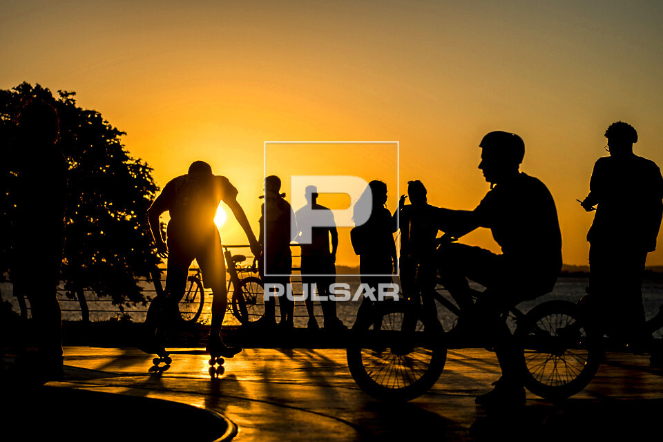 Jovens em pista de skate com o pôr do sol na orla do Guaíba - 