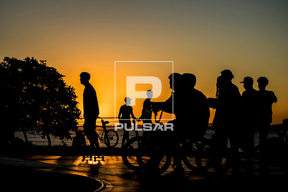 Adolescentes em pista de skate com o pôr do sol na orla do Guaíba - 