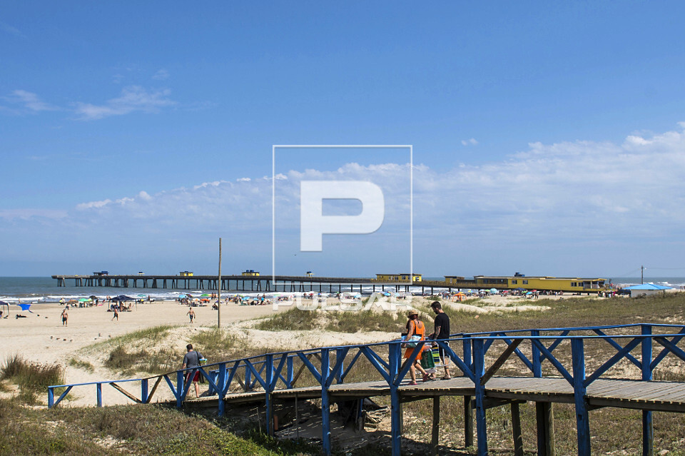 Banhistas atravessam ponte em direção da praia de Tramandaí
