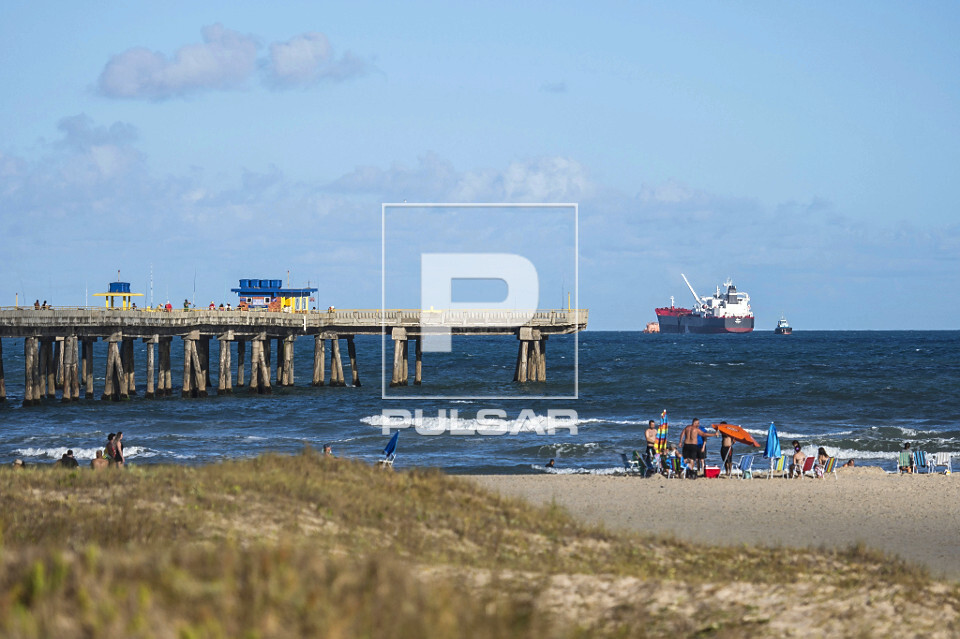 Plataforma marítima e banhistas na praia de Tramandaí