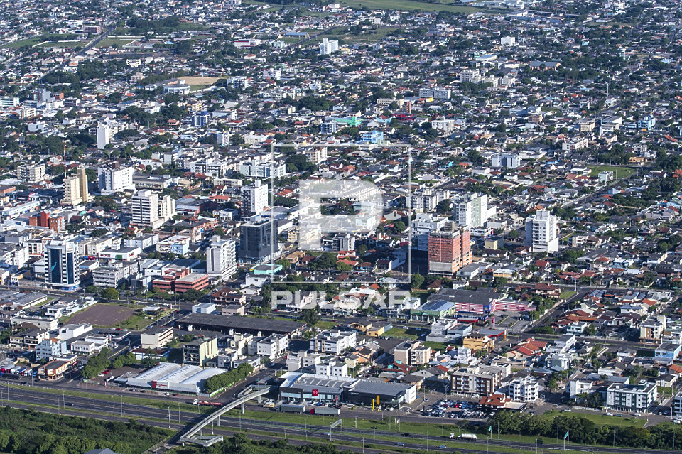 Vista de cima de parte da cidade com rodovia no primeiro plano