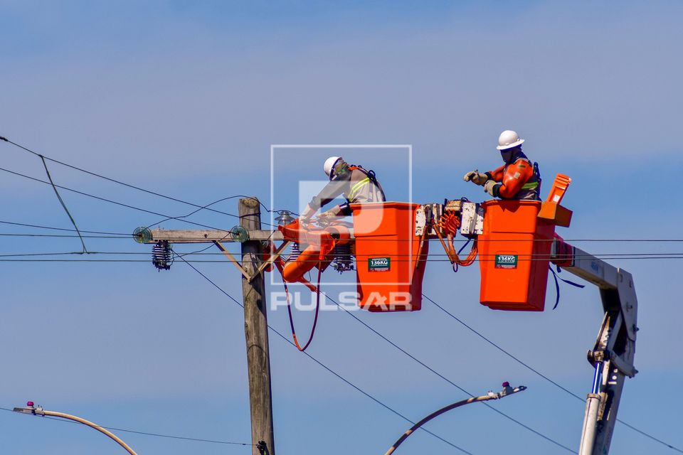 Trabalhadores fazendo reparo de rede elétrica após estragos causados por fortes ventos