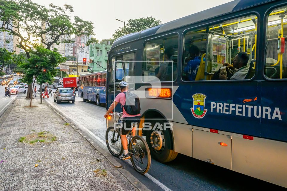 Ciclista disputando espaço com ônibus na Avenida Amazonas por ausência de ciclofaixa