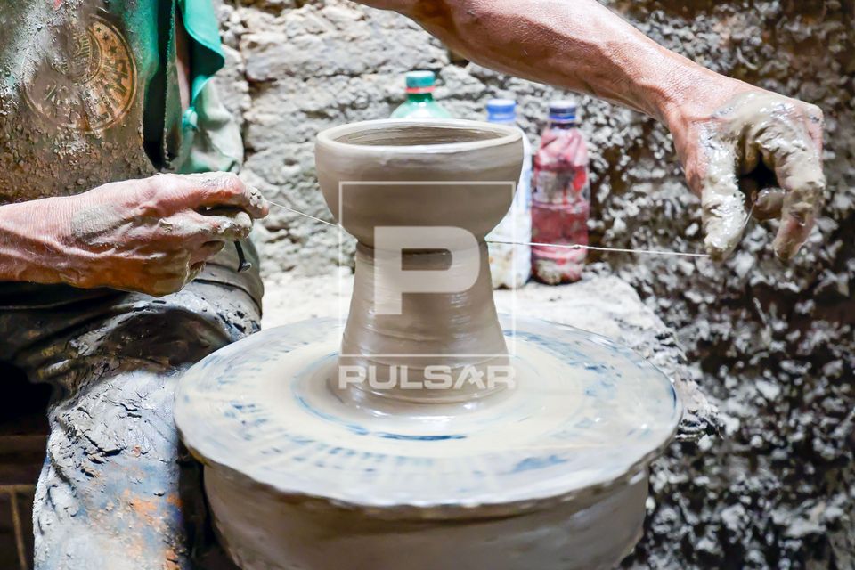Artesão dando acabamento em peça em argila no torno em sua oficina de cerâmica - Polo Cerâmico Artesanal d