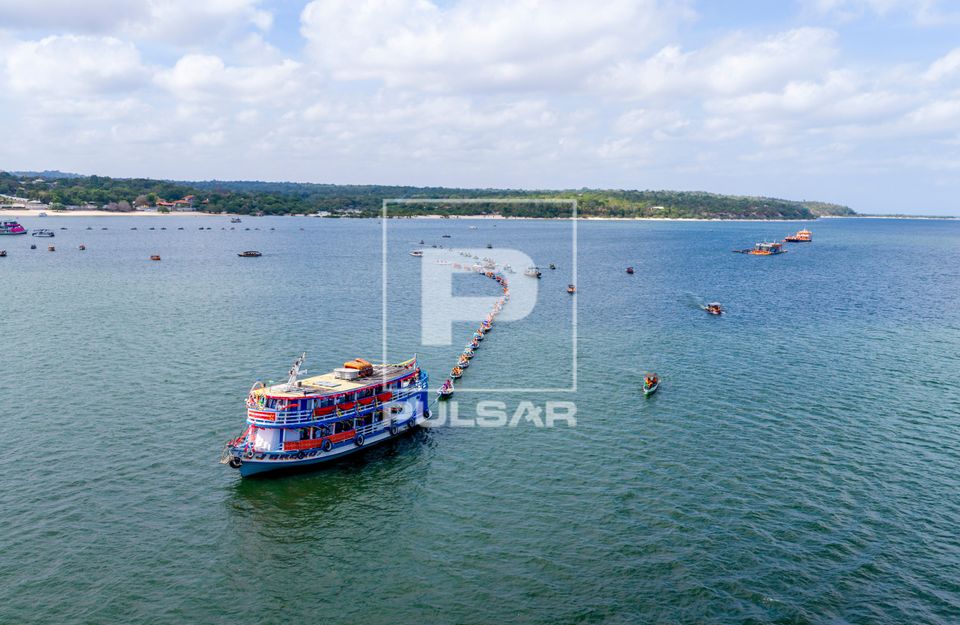 Festival do Sairé - barco a motor puxa canoas no rio Tapajós em direção da floresta para coleta dos Mastro