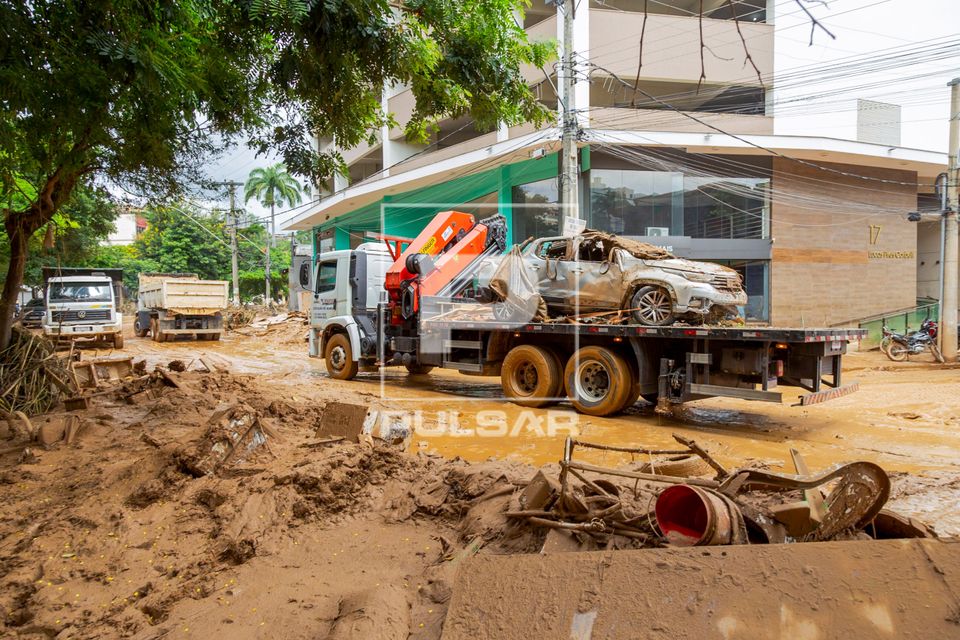 Caminhão transporta carro destruído na Avenida Beira Rio após enchente do Rio Ubá causada por fortes chuva