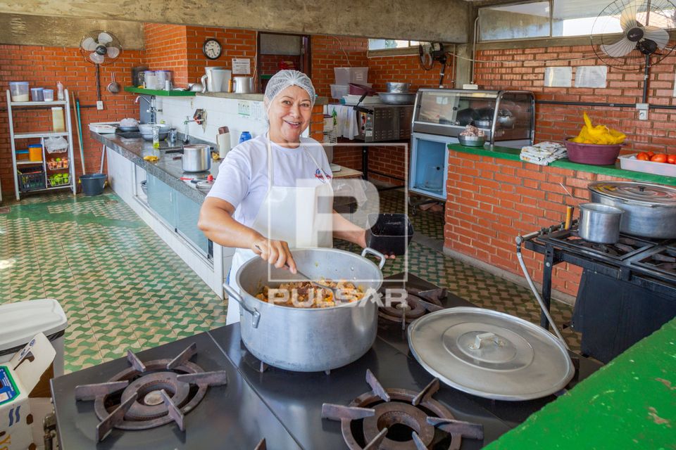 Cozinheira prepara almoço da manhã em escola