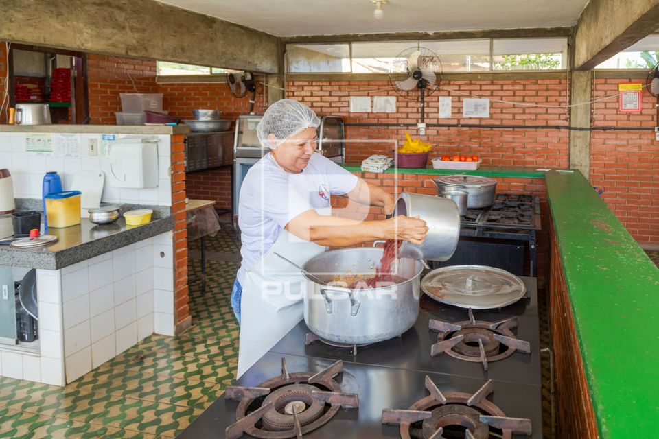 Cozinheira prepara almoço da manhã em escola