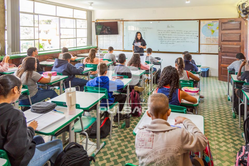 Professora fazendo leitura de texto em sala de aula 