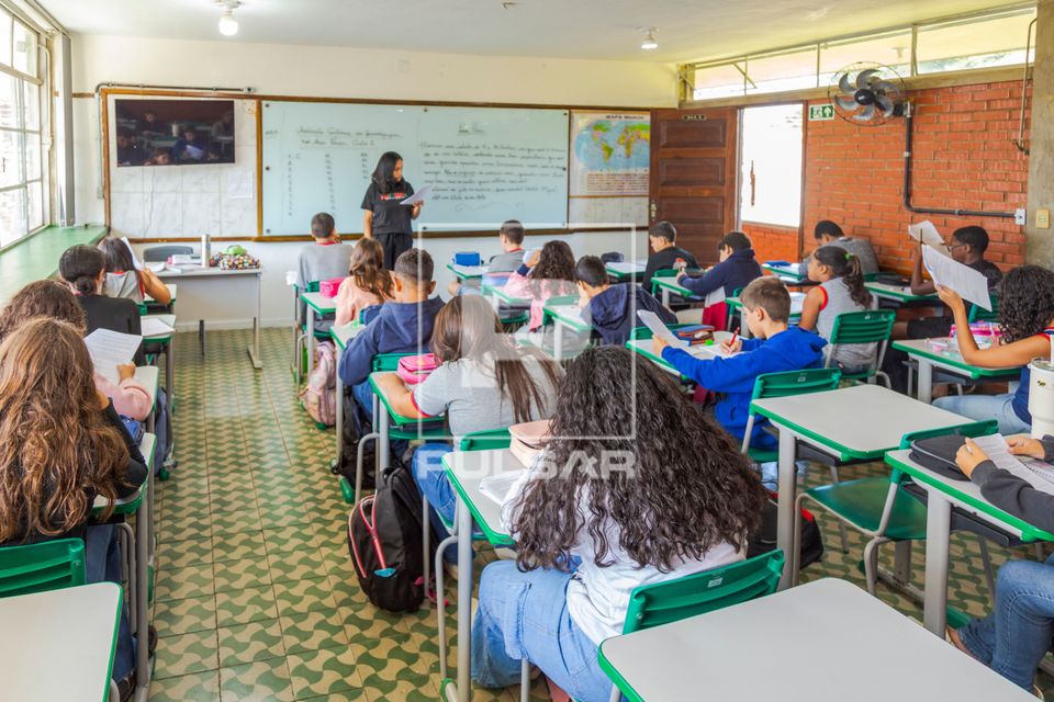 Professora fazendo leitura de texto em sala de aula 