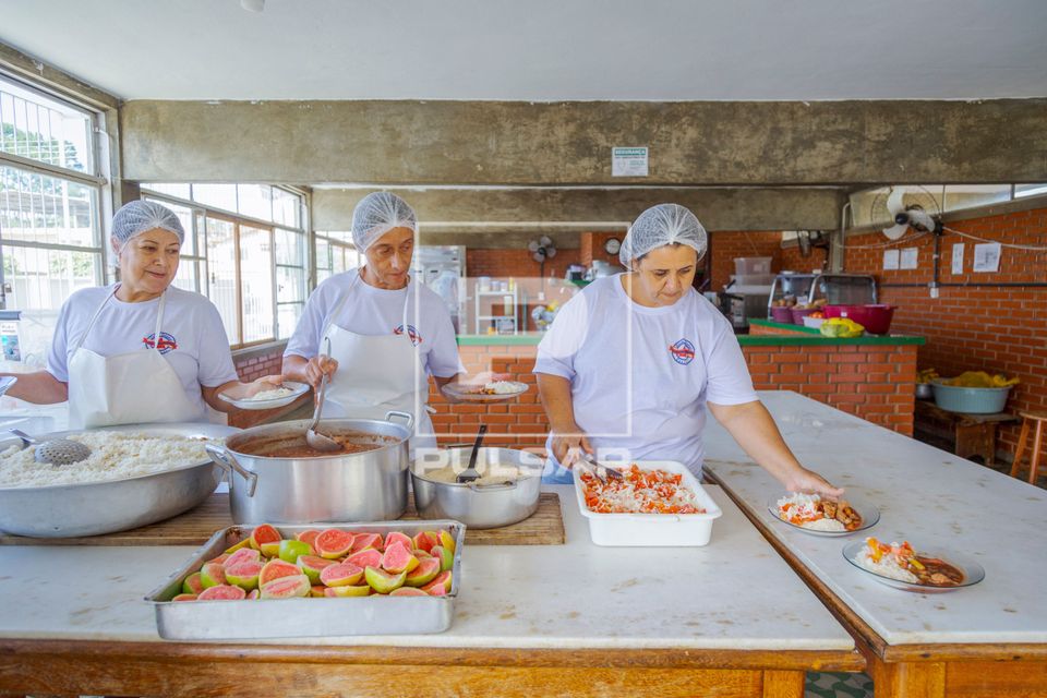 Cozinheiras servindo almoço preparado de manhã na escola