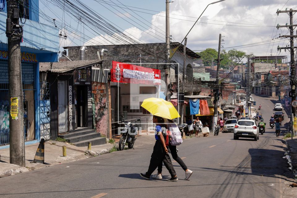 Pedestres atravessando rua do bairro Mauazinho