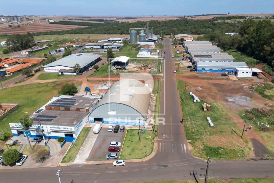 Vista de drone de galpões industriais , silos e área agrícola ao fundo
