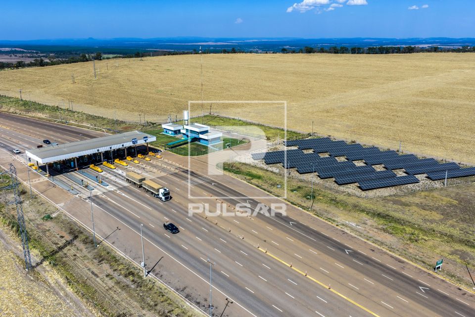 Vista de drone de praça de pedágio na Rodovia MT-130 no destaque placas solares e ao fundo área com palhada