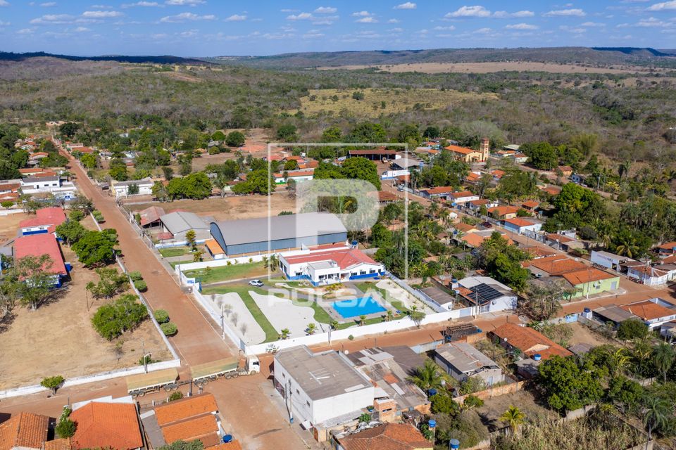 Vista de drone do CRAS Centro de Referência de Assistência Social e moradias no entorno e vegetação de cer