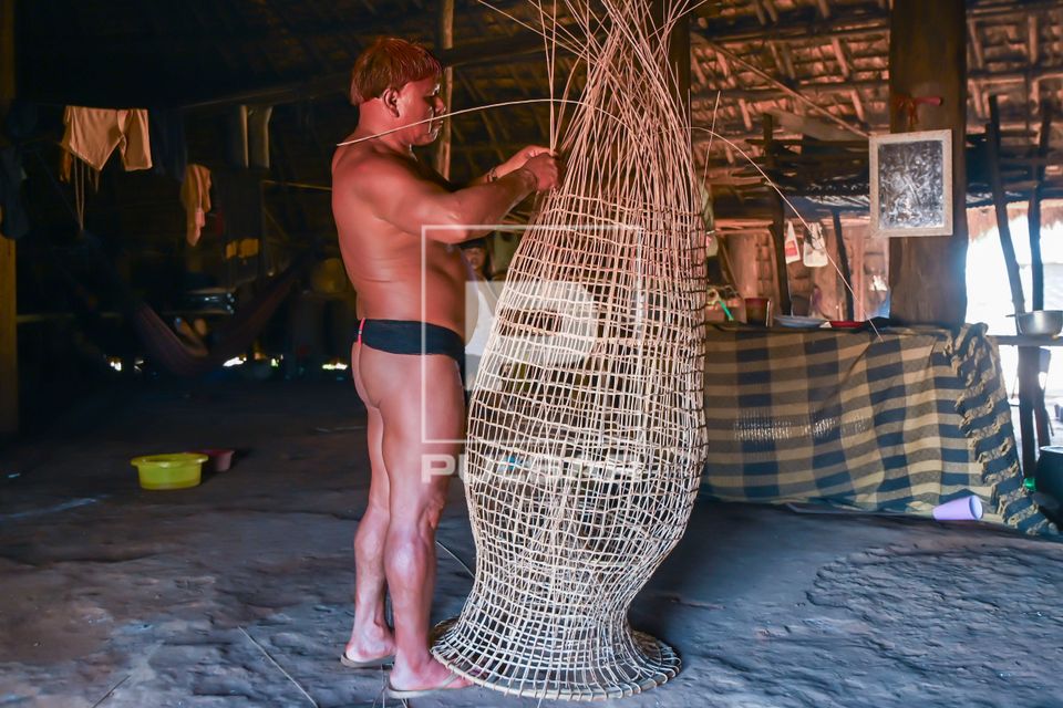 Indígena da etnia Wauja fazendo cesto armadilha covo de cipó para pegar peixe - Parque Indígena do Xingu