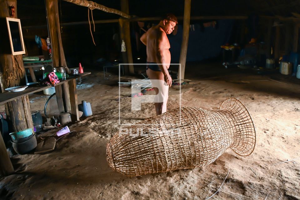 Indígena da etnia Wauja e cesto armadilha covo de cipó para pegar peixe - Parque Indígena do Xingu