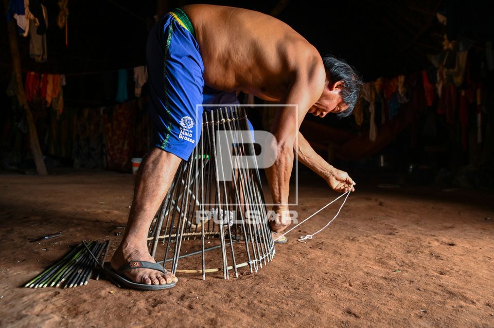 Indígena Waurá amarrando varetas em armadilha kuluto ou matapi de peixes em forma de cone - Parque Indígena