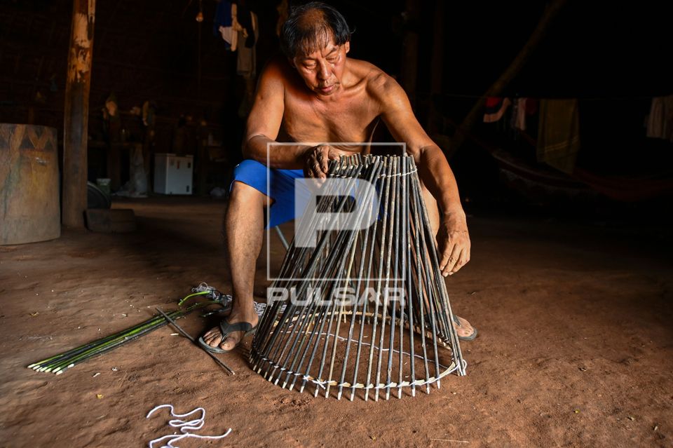 Indígena Waurá amarrando varetas em armadilha kuluto ou matapi de peixes em forma de cone - Parque Indígena