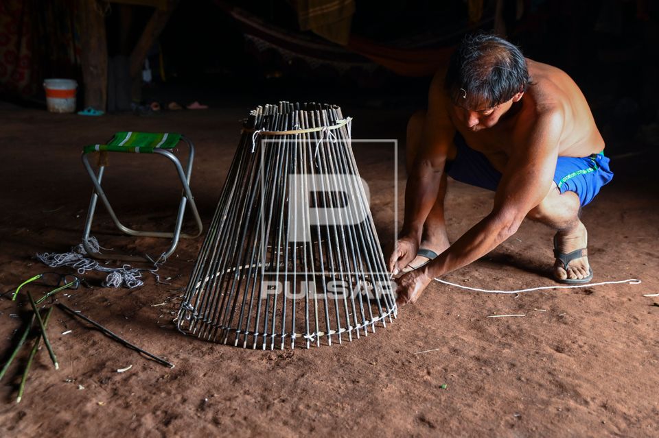 Indígena Waurá amarrando varetas em armadilha kuluto ou matapi de peixes em forma de cone - Parque Indígena