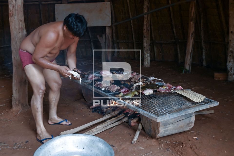Indígena Waurá da aldeia Piyulaga moqueando peixes - Parque Indígena do Xingu