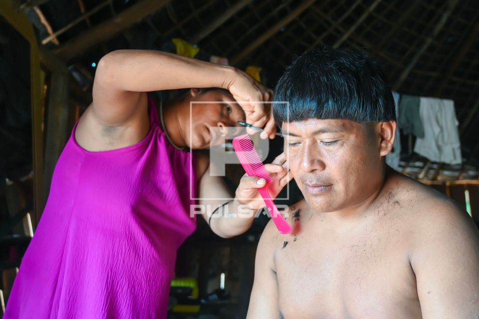 Mulher indígena Waurá da aldeia Topepeweke cortando cabelo do marido - Parque Indígena do Xingu