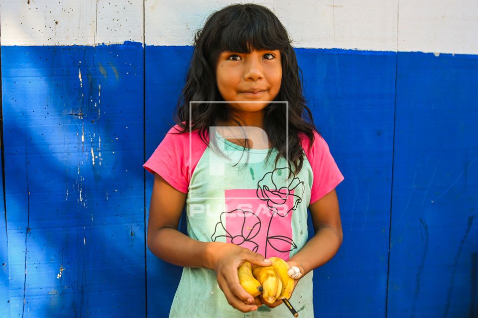 Menina indígena da etnia Waurá aldeia Piyulaga posando com bananas na mão - Parque Indígena do Xingu