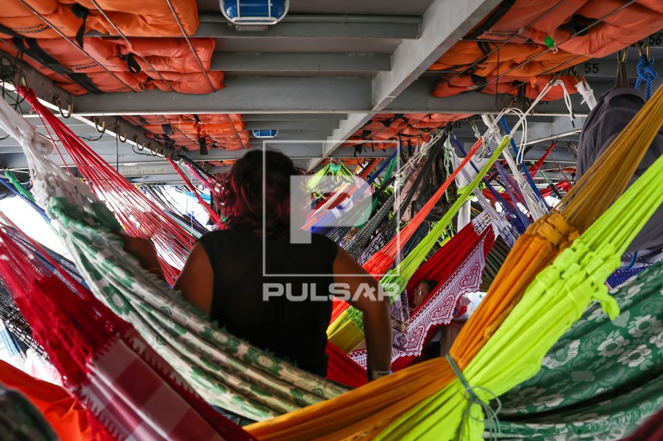 Vista interna de barco regional conhecido como recreio com redes de descanso para passageiros
