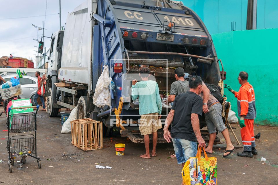 Pessoas procurando comida em caminhão de lixo no porto de Manaus