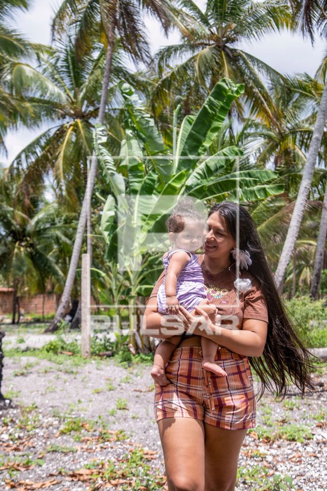 Mulher indígena da aldeia Tramataia da etnia Potiguar com a filha no colo 