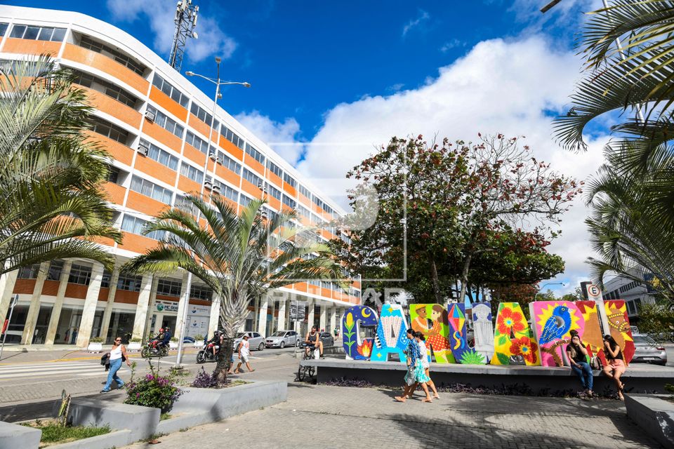 Praça com letreiro com nome da cidade e hotel no centro da cidade