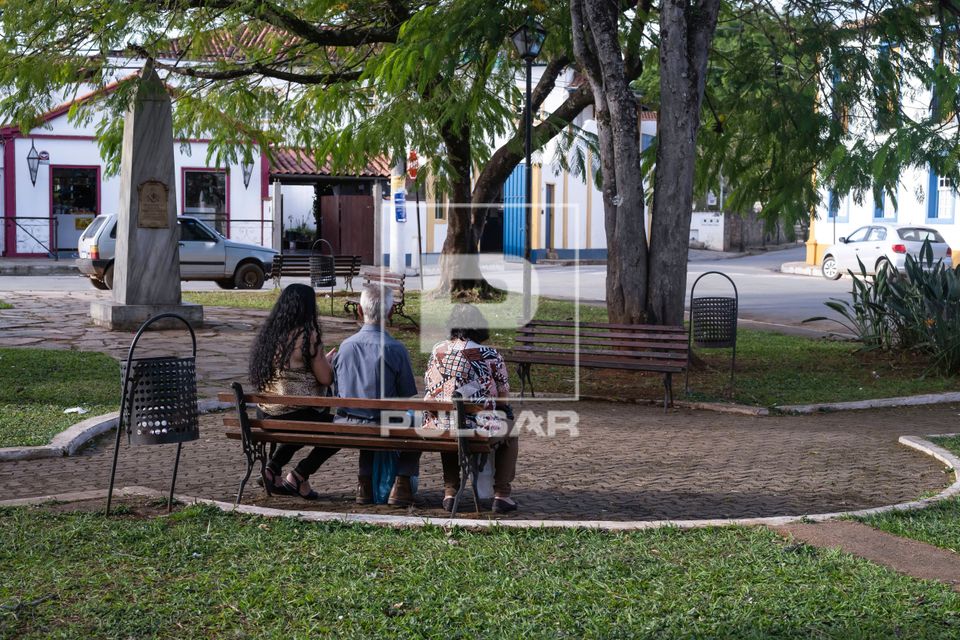 Família descansa em banco de praça
