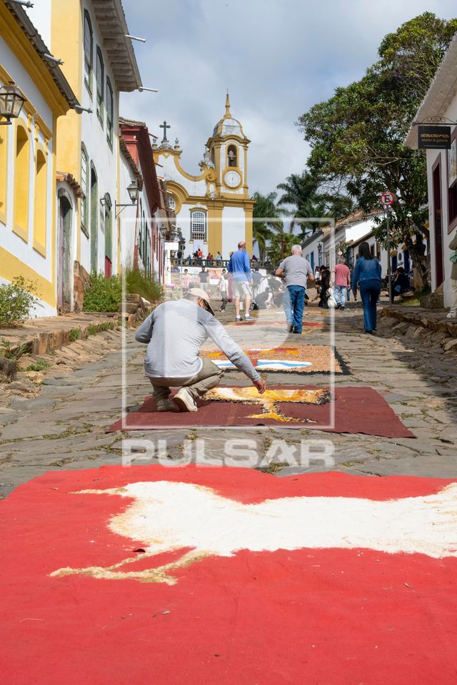 Voluntários decorando a Rua da Câmara com tapetes de serragem durante o Corpus Christi para a passagem da pr