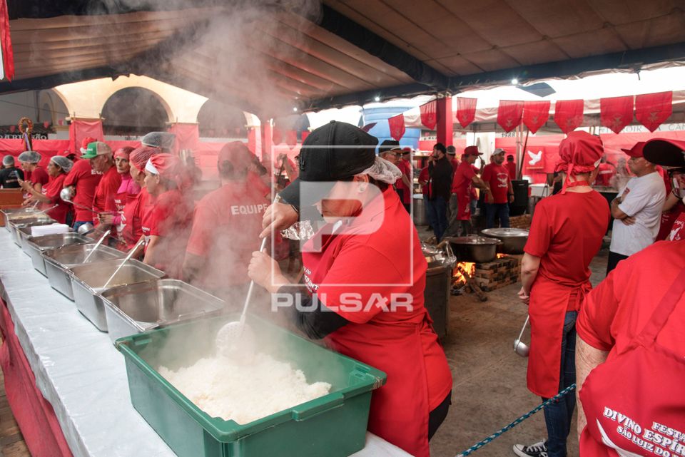 Voluntários servindo o afogado - prato típico da Festa do Divino Espírito Santo