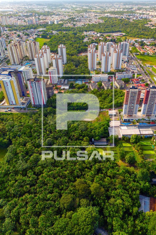 Vista de drone de edifícios residenciais no bairro Aleixo avançando sobre áreas verdes