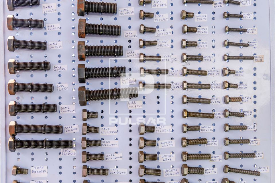 Parafusos de diferentes tamanhos e diâmetros em expositor de loja de materiais de construção
