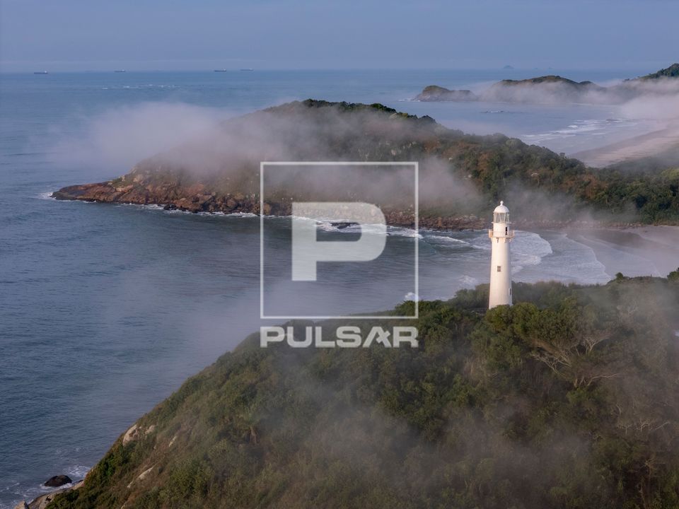 Nevoeiro ao amanhecer com Farol das Conchas sobre o Morro das Conchas no Parque Estadual da Ilha do Mel - Baí
