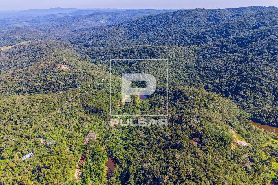Vista de drone de pequenos lagos e moradias de condomínio residencial em meio à mata atlântica 
