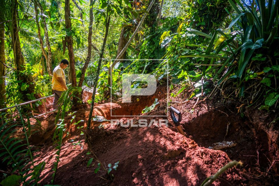 Pedreiro construindo fossa séptica residencial em área de mata atlântica
