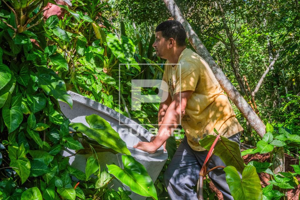 Pedreiro movimentando manilha de concreto para construção de fossa séptica residencial
