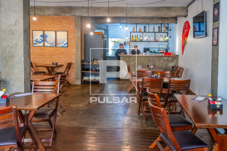 Vista interna de restaurante de comida japonesa - ao fundo chef de cozinha e ajudante