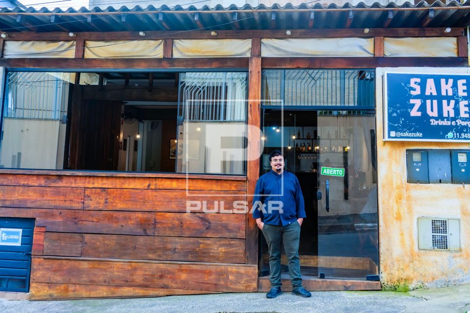 Chef de cozinha e proprietário em frente de seu restaurante de comida japonesa