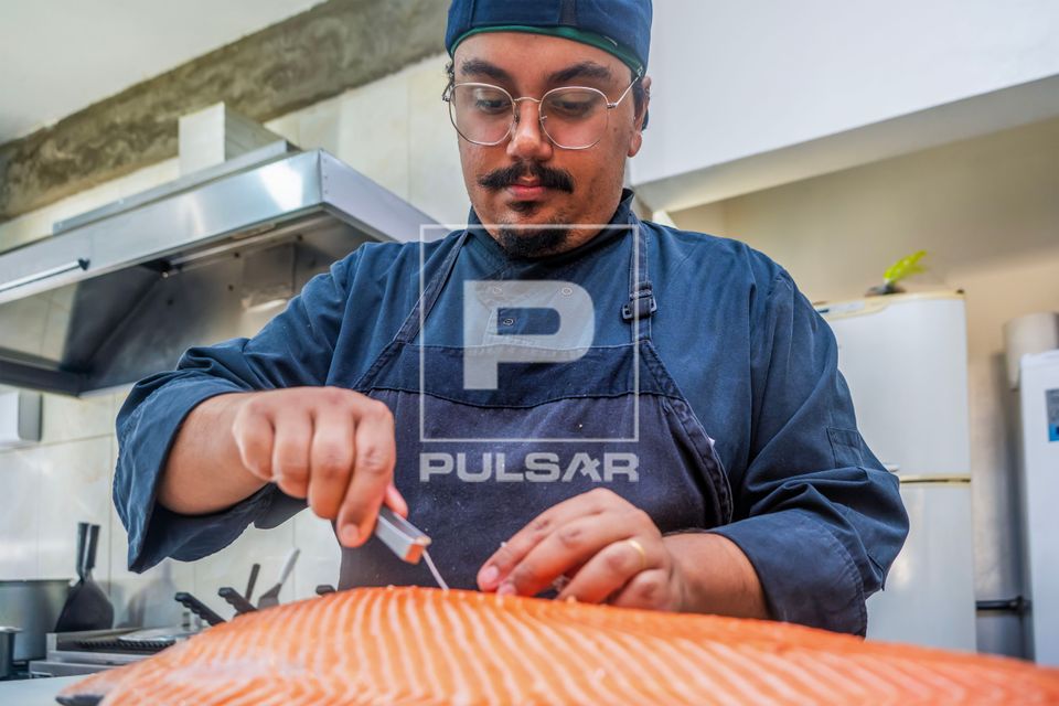 Chef de cozinha e proprietário de restaurante de comida japonesa usando pinça para retirar espinha do peixe 